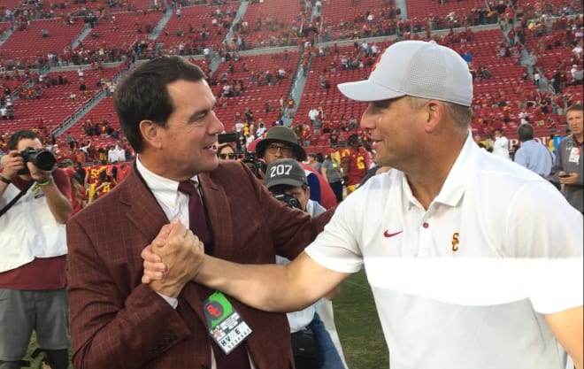 USC athletic director Mike Bohn congratulates coach Clay Helton after USC's 52-35 win over UCLA on Saturday in the Coliseum.