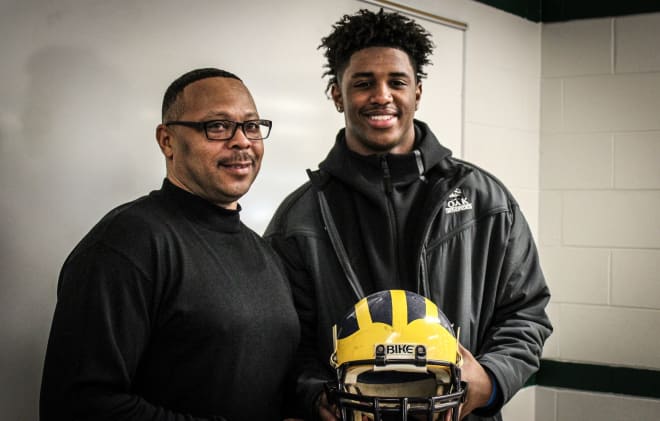 Detroit Cass Tech head coach Thomas Wilcher and five-star wide receiver Donovan Peoples-Jones pose with Wilcher's old helmet.