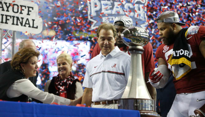 Nick Saban checks out the trophy after winning the Peach Bowl CFP semifinal.