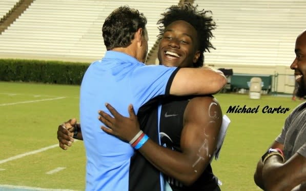 Carter hugs then-UNC Coach Larry Fedora after committing following the Freak Show in 2016.
