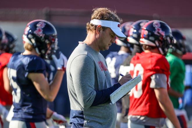 Ole Miss coach Lane Kiffin takes notes during practice Tuesday. 