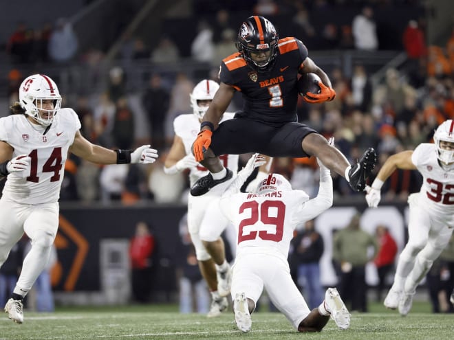 Oregon State running back Deshaun Fenwick (1) jumps over Stanford cornerback Terian Williams in a 62-17 victory for OSU.