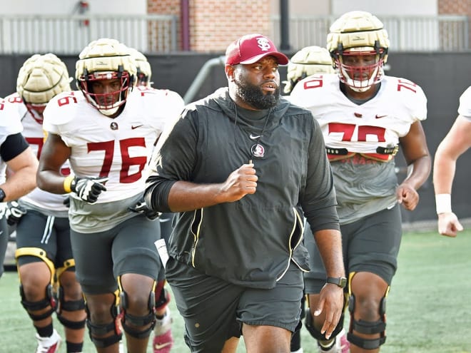 FSU offensive line coach Alex Atkins leads his players to a drill this preseason.