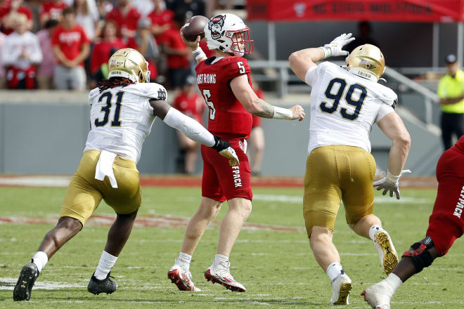 Irish defensive linemen Nana Osafo-Mensah (31) and Rylie Mills (99) bring the heat to NC State QB Brennan Armstrong.