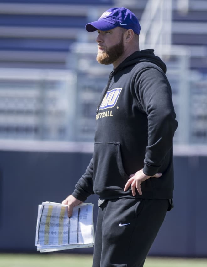 James Madison defensive coordinator Corey Hetherman watches the Dukes' defense as they run through a drill during a spring practice this past March.