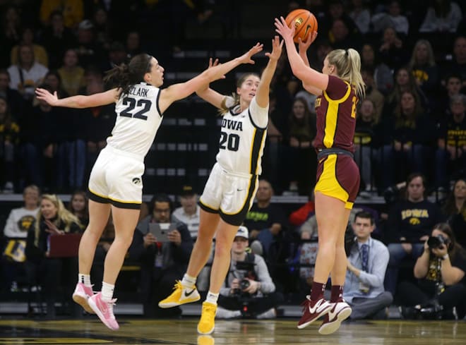 Iowa's Caitlin Clark (22) and Kate Martin (20) defend a Minnesota shot attempt Saturday, Dec. 30, 2023 at Carver-Hawkeye Arena.
