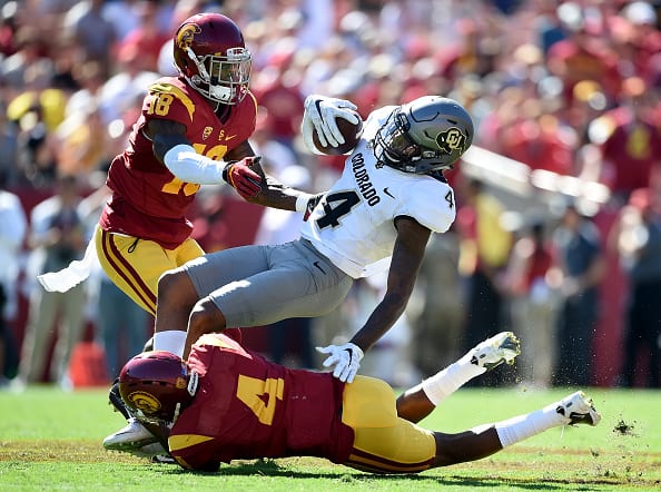 LOS ANGELES, CA - OCTOBER 08: Bryce Bobo #4 of the Colorado Buffaloes is tackled by Chris Hawkins #4 of the USC Trojans as Quinton Powell #18 comes into the play during the second quarter at Los Angeles Memorial Coliseum on October 8, 2016 in Los Angeles, California. (Photo by Harry How/Getty Images)