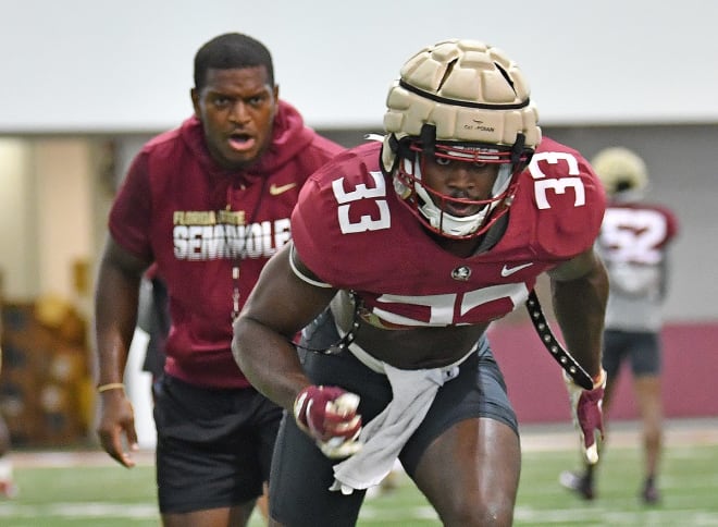 Florida State linebackers coach Chris Marve watches on as Amari Gainer goes through a drill in practice. 