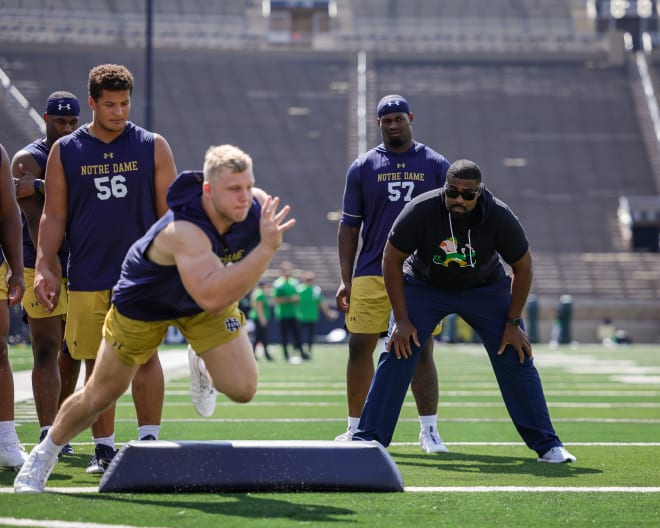 Notre Dame D-line coach Al Washington (right) watches defensive tackle Rylie Mills go through some warm-up drills last fall.