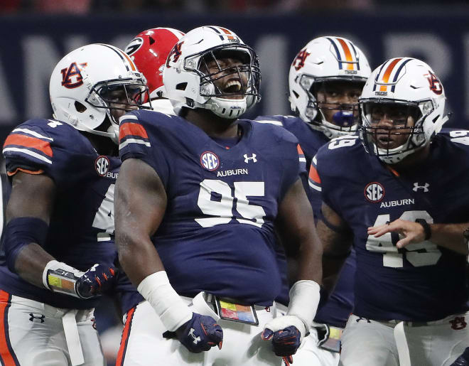 Auburn defensive lineman Dontavius Russell (95) celebrates tackling Georgia quarterback Jake Fromm during the first half of the Southeastern Conference championship NCAA college football game, Saturday, Dec. 2, 2017, in Atlanta. (AP Photo/David Goldman)