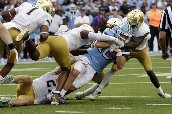 Notre Dame defenders Isaiah Foskey (7), Justin Ademilola ( middle), JD Bertrand (bottom) and TaRiq Bracy (right) converge of North Carolina QB Drake Maye on Saturday.