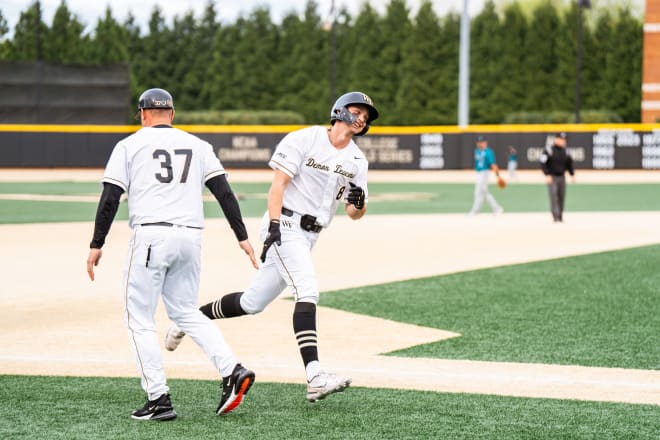 Wake Forest's Nick Kurtz rounds third base and celebrates with associate head coach Bill Cilento on Tuesday night. 