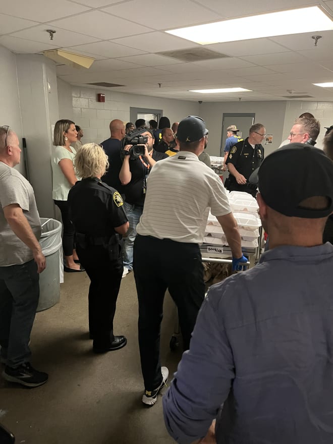 Jim Harbaugh pushes a cart of lunch trays through the halls of Genesee County Jail. (Brandon Justice/Rivals)