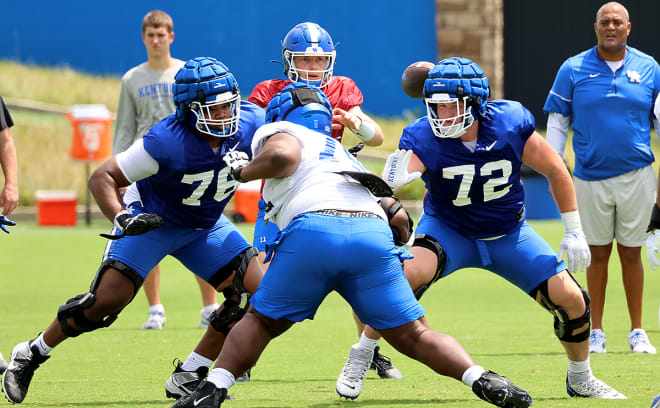 Kentucky offensive linemen Austin Ramsey (76) and Hayes Johnson (72) worked against nose tackle Dennious Jackson as quarterback Beau Allen awaited the snap during Friday's practice session at the JCFTC.