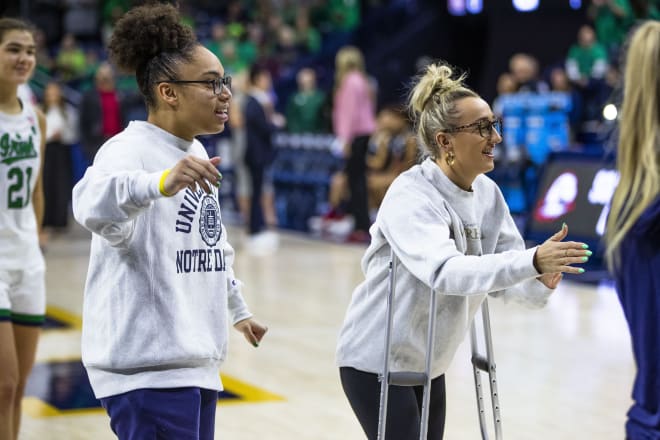 Injured guards Olivia Miles (left) and Dara Mabrey cheer on their Notre Dame teammates on Friday at Purcell Pavilion.