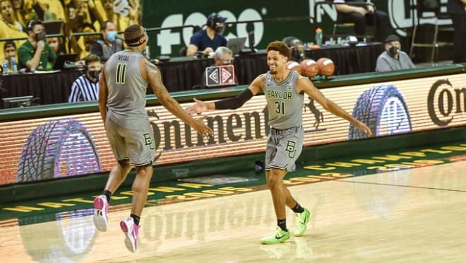 The two seniors, MacCio Teague (31) and Mark Vital (11) slap hands Sunday vs. Texas Tech.