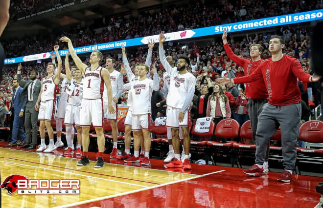 UW's bench, including Ballard (over No.1's shoulder), Higginbottom (right of 1), McGrory (behind Higginbottom), Cuevas (to his right) and Qawi (behind Cuevas), get ready to celebrate Brevin Pritzl's 3-pointer.