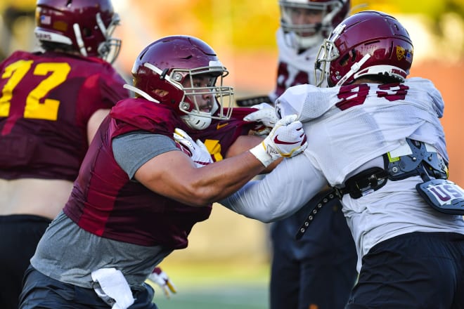 Trojans center Brett Neilon takes on Marlon Tuipulotu on Monday.