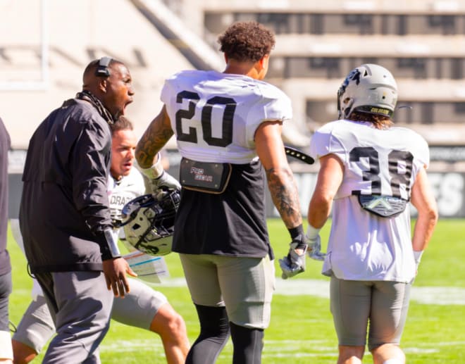 Aziz Shittu shares a word with Robert Barnes and Steele Dubar during Colorado's recent spring showcase