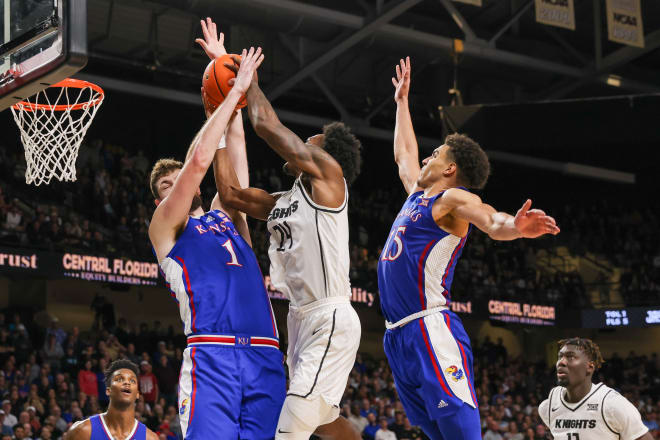 Kansas' Hunter Dickinson (1) and Kevin McCullar (15) defending UCF's Jaylin Sellers (24)