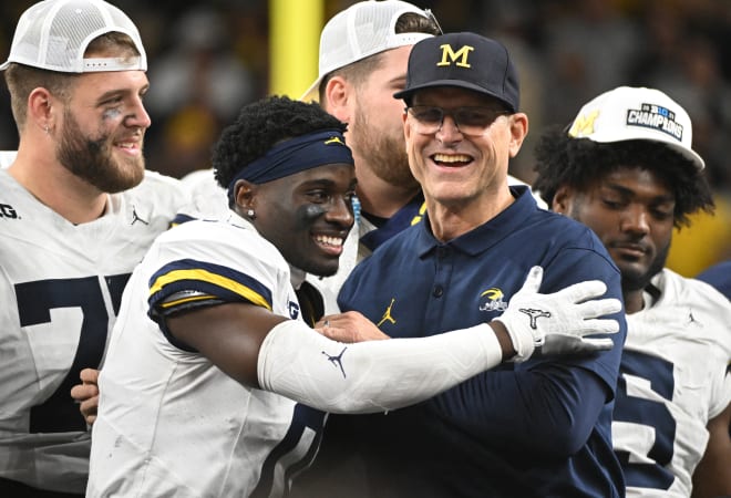 Michigan Wolverines head coach Jim Harbaugh celebrates with defensive back Mike Sainristil (0) after winning the Big Ten Championship game against the Iowa Hawkeyes at Lucas Oil Stadium. Photo | Robert Goddin-USA TODAY Sports