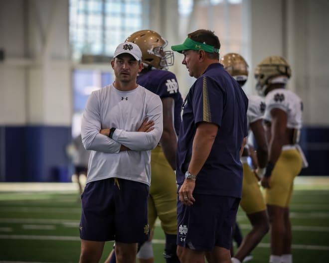 Offensive coordinator Tommy Rees and defensive coordinator Al Golden talk during an Irish training camp session last August.