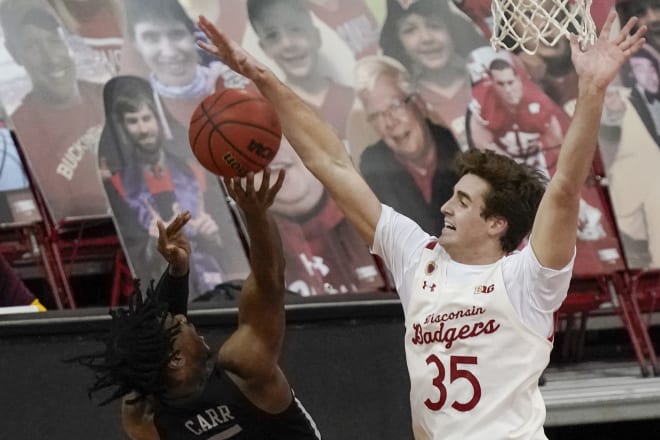 Wisconsin's Nate Reuvers blocks the shot of Minnesota's Marcus Carr, who struggled to solve the Badgers' defense