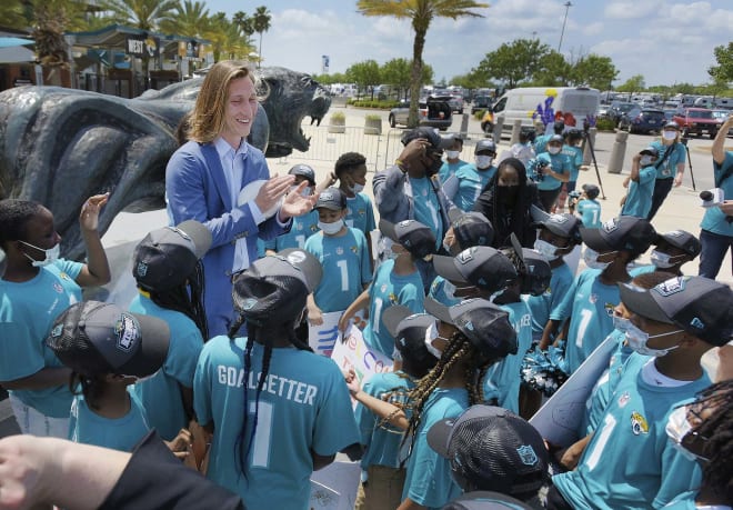 Former Clemson quarterback Trevor Lawrence applauds students from Long Branch Elementary School who greeted him and his wife upon their arrival in Jacksonville, Fla., Friday.