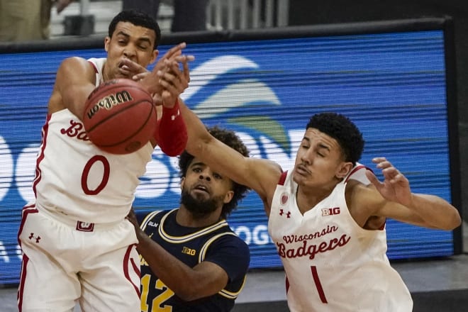 Wisconsin's D'Mitrik Trice and Jonathan Davis go after a rebound against Michigan's Mike Smith during the second half of Wisconsin's 67-59 loss to the Wolverines.