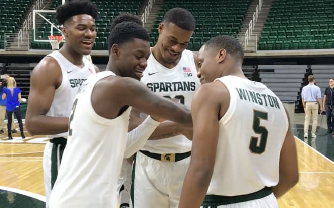 Cassius Winston and Xavier Tillman inspect Mark "Rocket" Watts' tattoos during Michigan State Basketball Media Day on Tuesday as freshman Julius Marble looks on. 