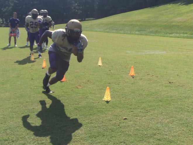 James Madison senior running back Taylor Woods carries the ball through a drill at James Madison's practice on Thursday in Harrisonburg.