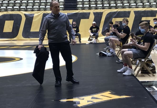 Brian Smith unveils a Big XII logo on Mizzou's mat at the Hearnes Center Thursday afternoon