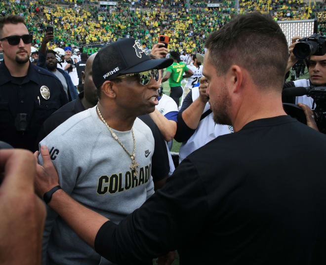 Colorado's Deion Sanders, left, and Oregon's Dan Lamming, right 