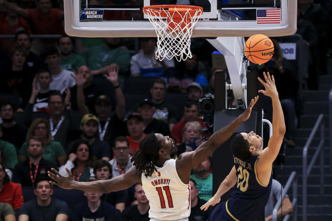 Rutgers' Clifford Omoruyi (11) defends as Notre Dame's Paul Atkinson Jr. (20) shoots during the first half of a First Four game in the NCAA men's college basketball tournament, Wednesday, March 16, 2022, in Dayton, Ohio.