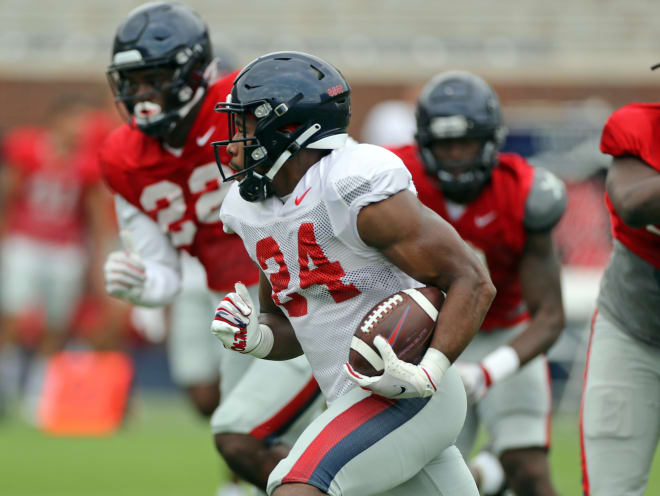 Running back Snoop Conner (24) breaks a long run as defensive lineman Tariqious Tisdale (22) pursue during the Rebels' scrimmage Sunday at Vaught-Hemingway Stadium.
