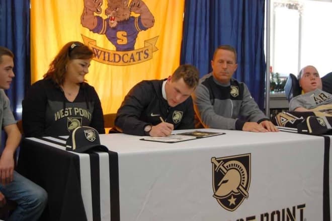 Rivals 2-star LB Cameron Hoelscher signs as he is surrounded by his parents and two brothers