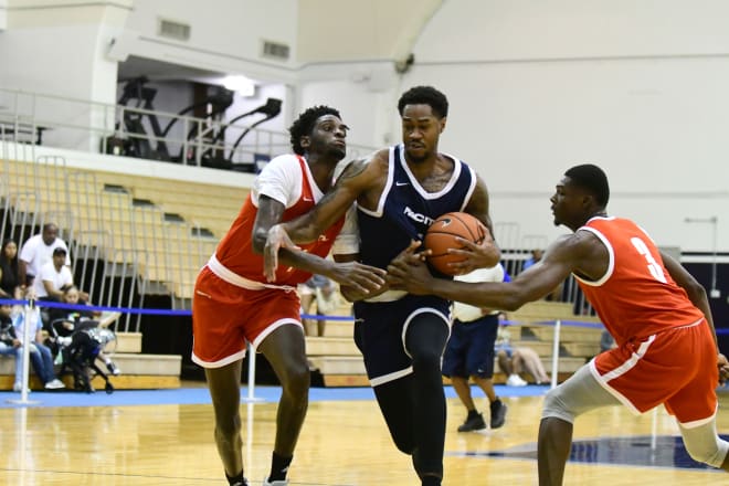 VJ King in the lane, guarded by Ticket Gaines (left) and D'Ante Bass. 