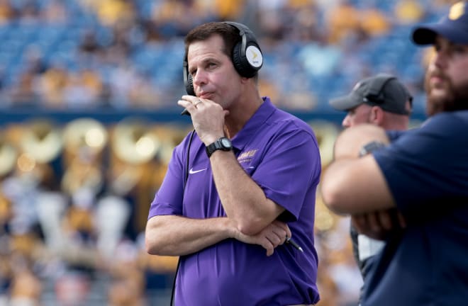 James Madison coach Curt Cignetti watches the scoreboard and talks on his headset during the Dukes' season-opening loss against West Virginia earlier this season in Morgantown, W.Va.