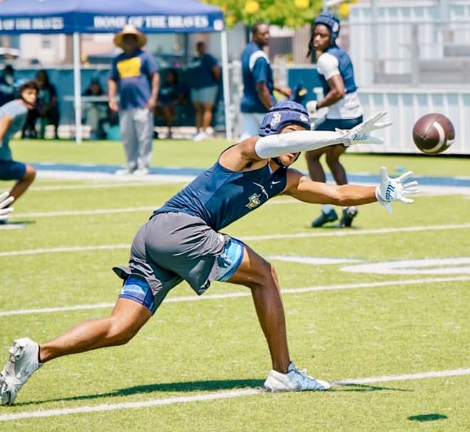 Madden Williams, a 2026 receiver from Bellflower (Calif.) St. John Bosco, sports a pair of UCLA-branded gloves during his high school program’s Brave 8 tournament in July. 