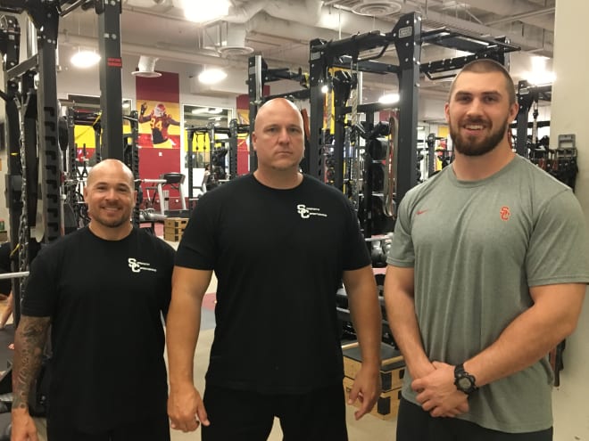 New USC head strength and conditioning coach Aaron Ausmus (middle) with two of his assistants, Steve Novencido (left) and Jared Klingenberg in the Trojans weight room last Friday.