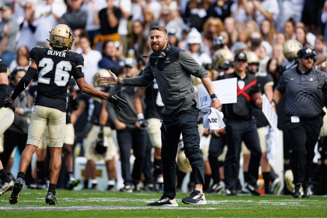 Interim HC Mike Sanford high fives cornerback Jason Oliver on Oct. 15.