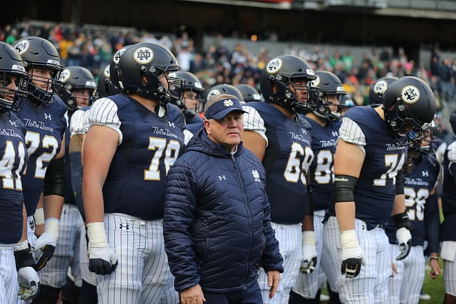Guards Tommy Kraemer (78) and Aaron Banks (69) fittingly flank head coach Brian Kelly prior to last year's Syracuse game.