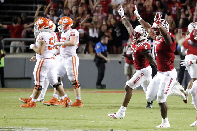 Clemson players walk off the field Saturday night in Carter-Finley Stadium after dropping a double overtime decision to N.C. State.