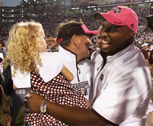 Mississippi State quarterback coach Brian Johnson, right celebrates the 38-23 win over No. 2 Auburn with head coach Dan Mullen and his daughter, Breelyn, after their NCAA college football game in Starkville, Miss., Saturday, Oct. 11, 2014.