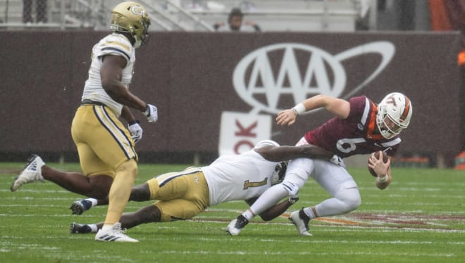 Virginia Tech quarterback Grant Wells, right, is tackled by Georgia Tech's Charlie Thomas during last weekend's game. 