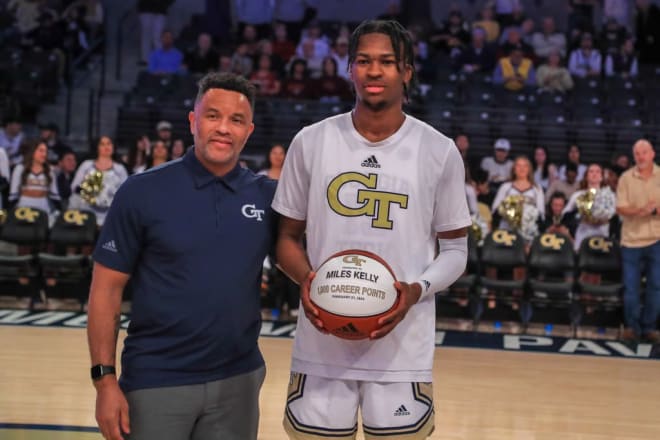 Damon Stoudamire and Miles Kelly celebrate Kelly's 1,000 career point scored at Tech with a ball before the game