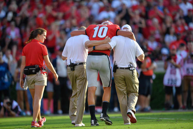 Georgia Bulldogs quarterback Jacob Eason (10) is helped off the field after being injured against the Appalachian State Mountaineers during the first quarter at Sanford Stadium. Photo  Credit: Dale Zanine-USA TODAY Sports