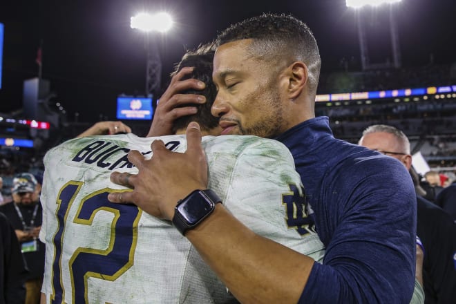Notre Dame QB Tyler Buchner (12) and head coach Marcus Freeman embrace after ND's Gator Bowl win over South Carolina.