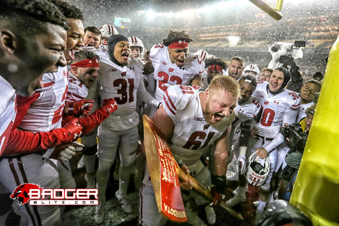 Tyler Biadasz (61) chops down the goal post following Wisconsin's 2019 victory in Minneapolis, clinching another BIg Ten West title.