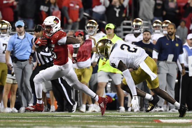 Notre Dame safety DJ Brown (2) stumbles as he attempts to tackle Louisville running back Jawhar Jordan, who is headed for the end zone.